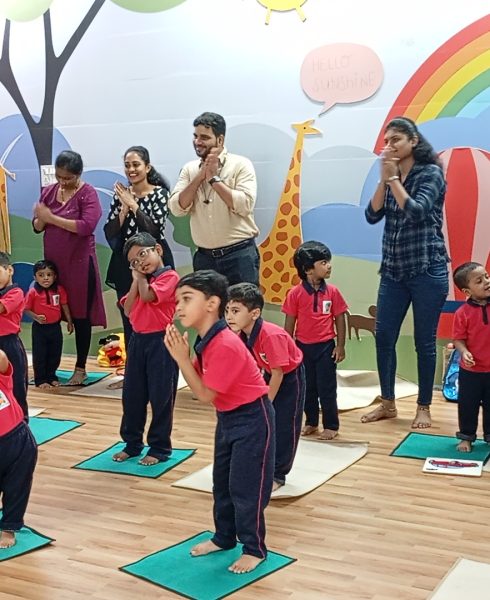Parents and kids dancing together in a vibrant preschool environment